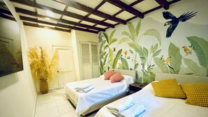 A room with two beds, a large window, a wall with a tropical mural, and a ceiling with exposed beams. - Cozy duplex apartment at the City Center (Cartagena de Indias)