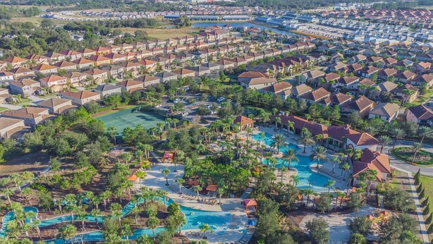 A residential area with a large swimming pool surrounded by palm trees and houses. - Luxury Villa w/ Pool & Disney Themes Solterra (Davenport)