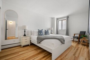 2 habitaciones, escritorio y tabla de planchar con plancha