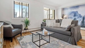 Un salon moderne avec un canapé, une table basse et une grande fenêtre.