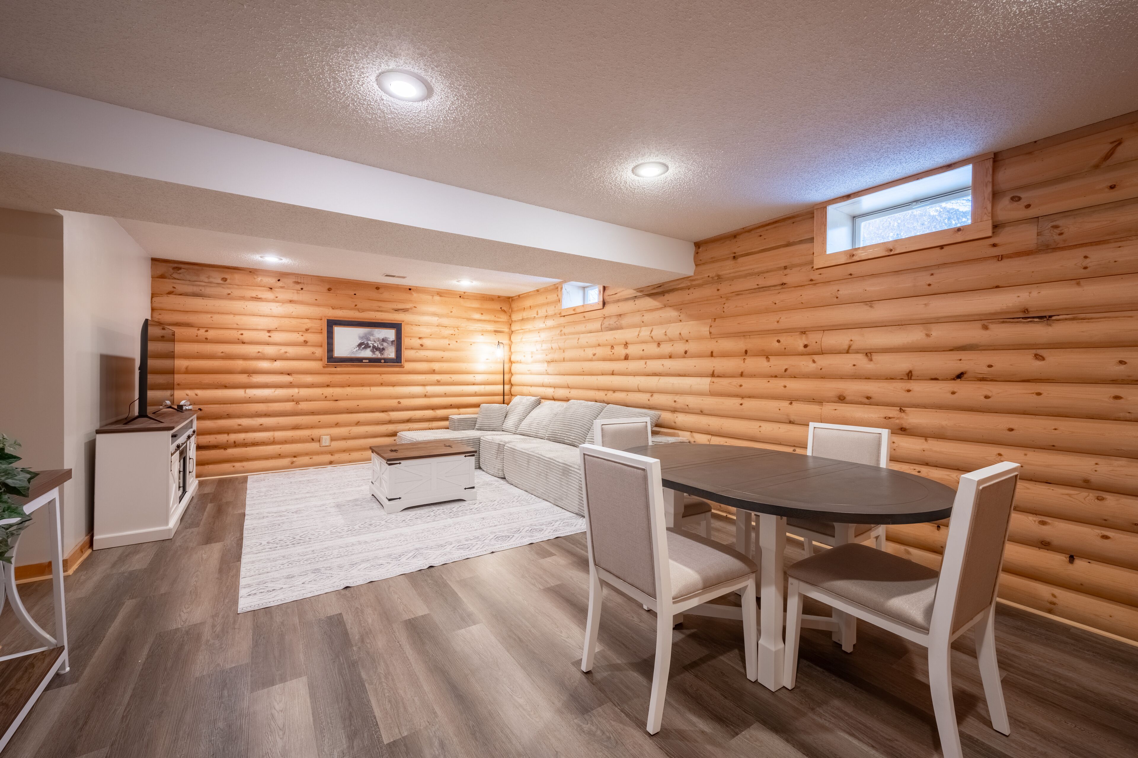 L’intérieur d’une cabane en rondins comprend un coin repas, un canapé et une petite cuisine.