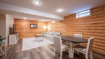 L’intérieur d’une cabane en rondins comprend un coin repas, un canapé et une petite cuisine.