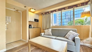 A compact living space with a kitchenette, a sofa, and a dining table. - Cozy studio in lovely Honolulu with Lanai & refreshing AC for your stay (Honolulu)