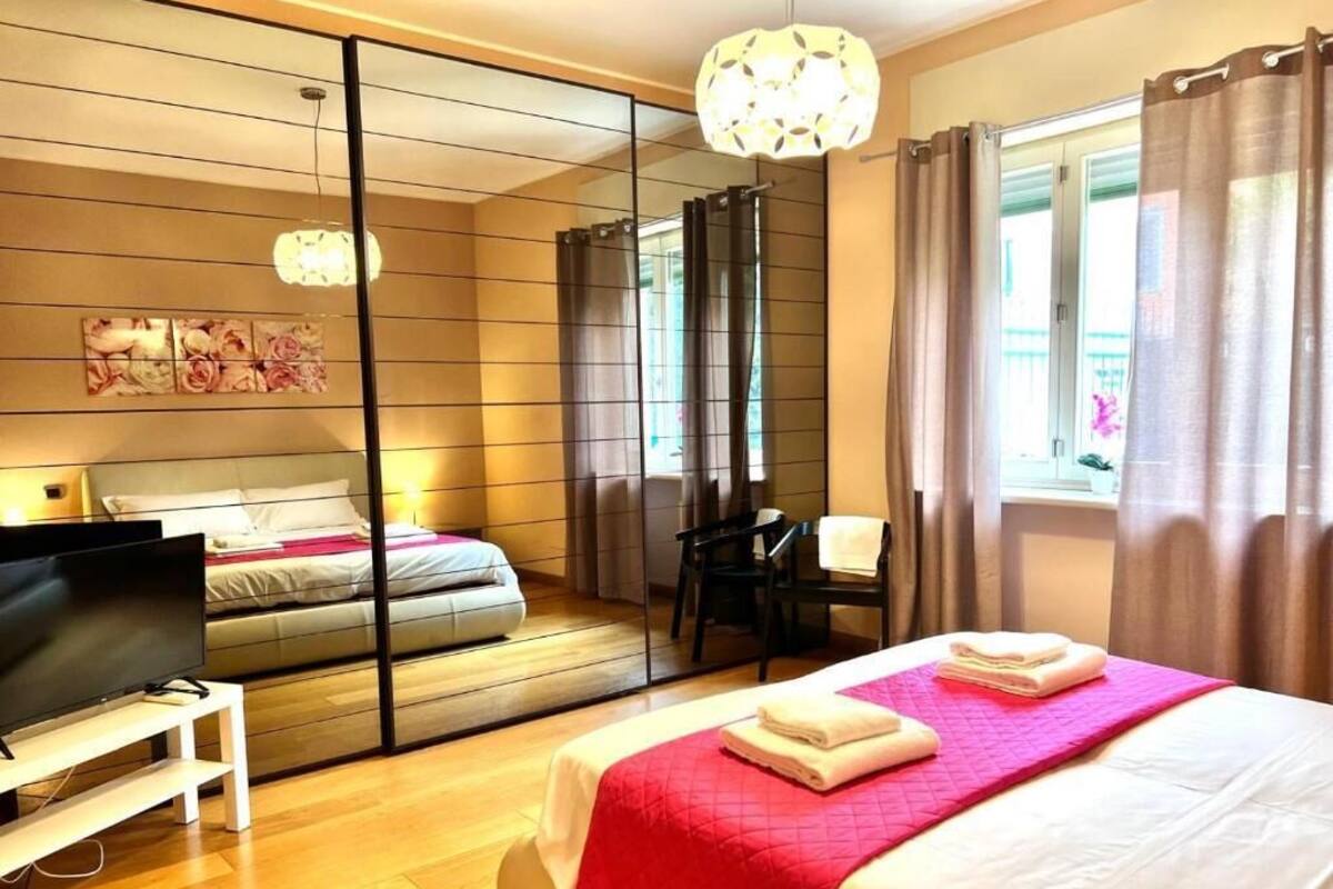A hotel room with a large bed, a TV, a desk, and a chair.