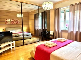 Una camera d'albergo con un letto grande, una televisione, una scrivania e una sedia.
