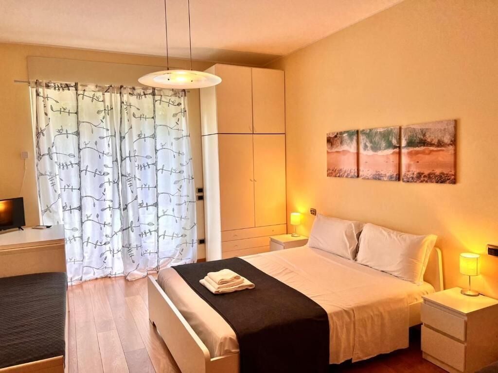 Une chambre d’hôtel avec un lit, des tables de chevet, une télévision et des œuvres d’art accrochées au mur.