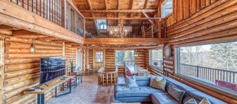 Grand chalet en bois rond relaxant avec un spa.