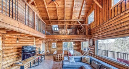 Grand chalet en bois rond relaxant avec un spa.