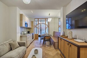Une cuisine moderne avec des meubles en bois, un coin repas comprenant une table et des chaises, et un canapé.