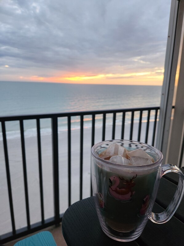 A glass mug with ice cubes on a balcony overlooking the ocean at sunset. - “Sun, Sand & Spectacular Views Family-Friendly Madeira Beach Condo-Corner Unit (Madeira Beach)