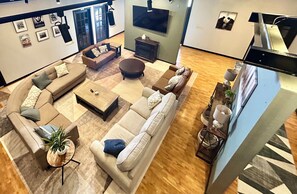 A spacious living area with a sectional sofa, a coffee table, and a fireplace. - The Hidden Gem- Superb 7-bedroom Studio with arcade, theater and more! (Springfield)