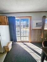 Una habitación pequeña y funcional con una puerta corrediza de vidrio que da a un espacio al aire libre.