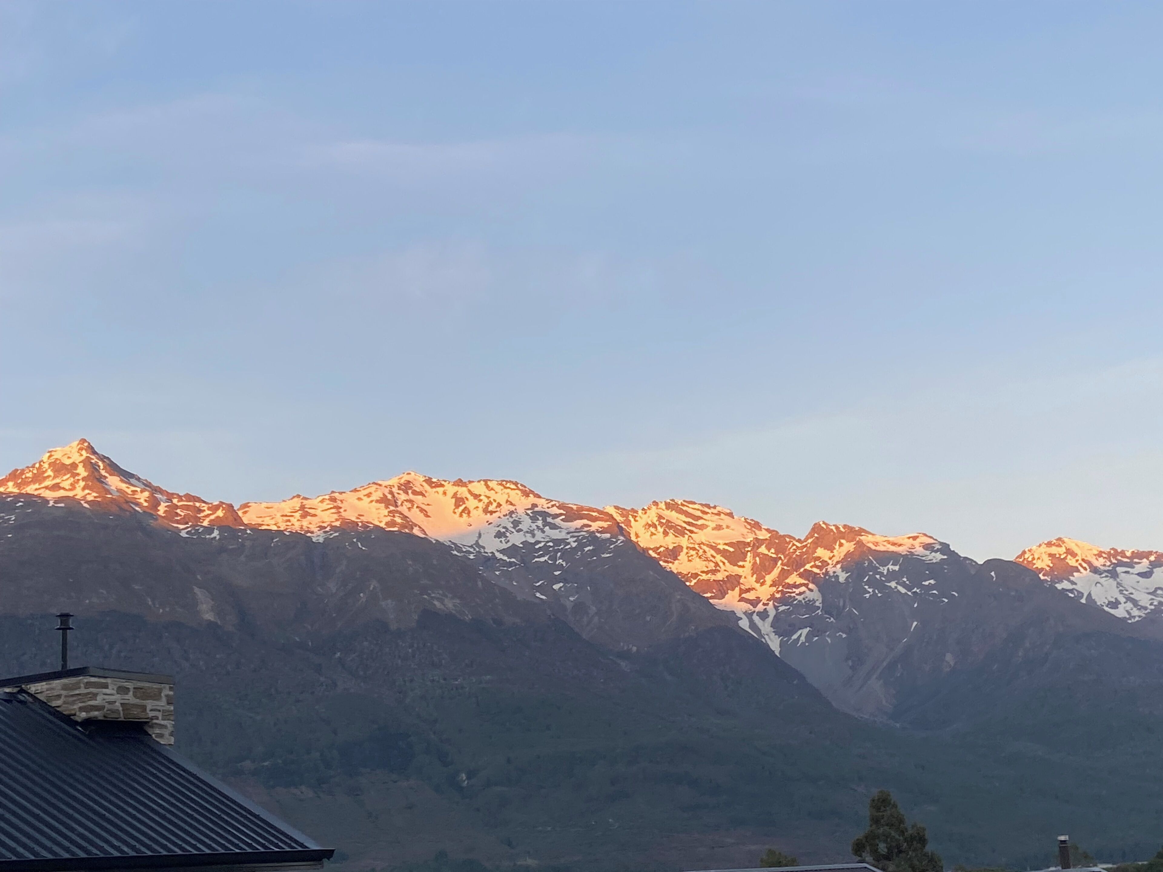 A mountain range with snow-capped peaks and a clear sky.
