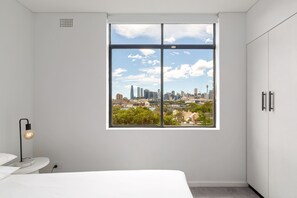 Una camera da letto con un'ampia finestra che si affaccia su una vista panoramica della città.
