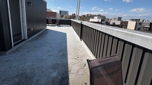Una terrazza sul tetto con vista sullo skyline della città, una porta e una ringhiera.