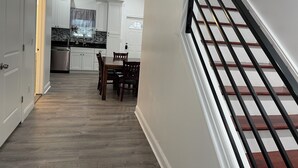 Una cucina moderna con mobili bianchi, una lavastoviglie in acciaio inossidabile e un piano di lavoro nero.