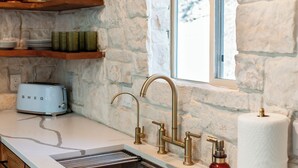 A kitchen with a stone wall, wooden shelves, a toaster, a sink, and a window. - Breathtaking View 12 Min to Downtown (Durango)