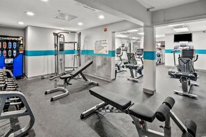 A gym with various exercise equipment, a water dispenser, and a mirrored wall. - Beachfront Condo with Balcony and Resort Pools (North Myrtle Beach)
