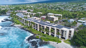 Un hotel frente al mar con varias edificaciones, una playa y vistas al océano.