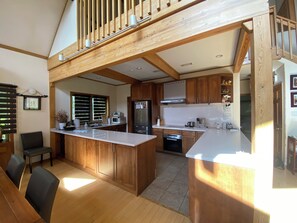 A spacious kitchen with wooden cabinets, a central island, and a dining area with chairs. - LUXURY SKI OR GOLF HOME 
4 Bedroom, 3.5 Bathroom 
Walk to Rusutsu Resort, Japan (Rusutsu, Abuta-Gun)