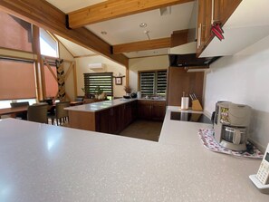 A kitchen with a large island, wooden beams, a coffee machine, and a sink. - LUXURY SKI OR GOLF HOME 
4 Bedroom, 3.5 Bathroom 
Walk to Rusutsu Resort, Japan (Rusutsu, Abuta-Gun)