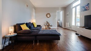 Un salon moderne avec un canapé, un téléviseur et un coin repas.