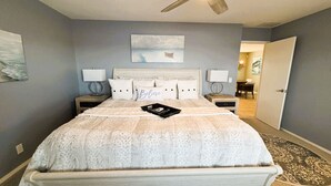 A bedroom with a bed, two bedside tables, a ceiling fan, and artwork on the walls. - Skytop - Hands down the best view on Beaver Lake (Rogers)