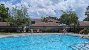 A swimming pool with lounge chairs and a no diving sign.