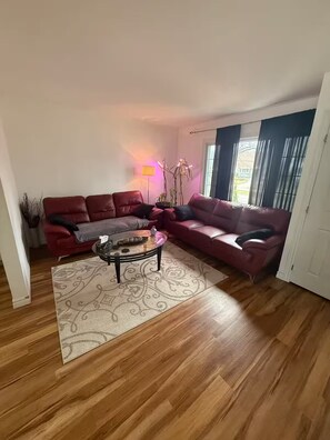 Una sala de estar con un sofá modular, una mesa de centro y una lámpara de pie.