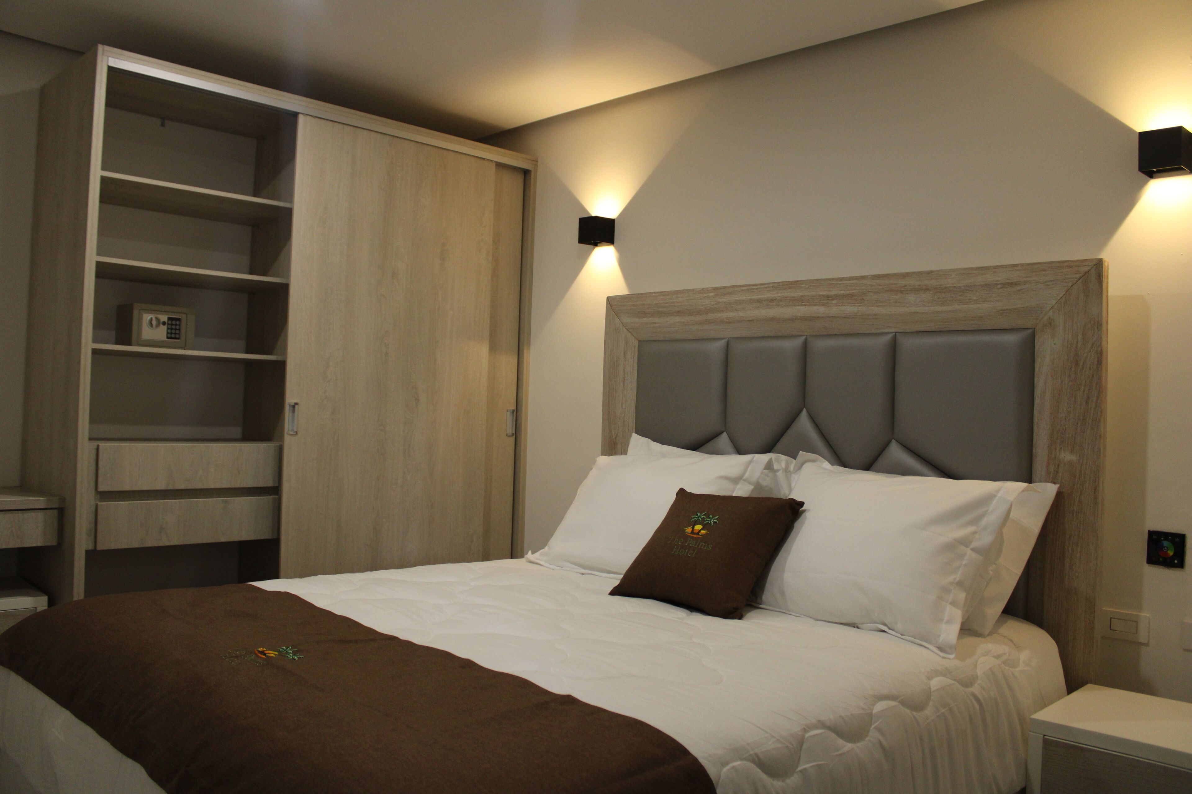 A bedroom with a bed, a wardrobe, and a nightstand.