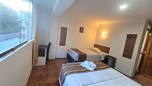 A hotel room with two beds, a desk, and a window. - REFUGIO SAGRADO BOUTIQUE (Ollantaytambo)