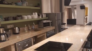Una cocina moderna con lavavajillas de acero inoxidable, horno empotrado y placa de inducción negra.