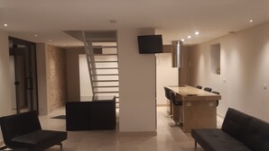 Una sala de estar moderna con un sofá, una mesa de centro y una escalera que sube a otro nivel.
