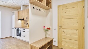 Eine moderne Küche mit weißen Schränken, einer Holz Arbeitsplatte und einem eingebauten Backofen.