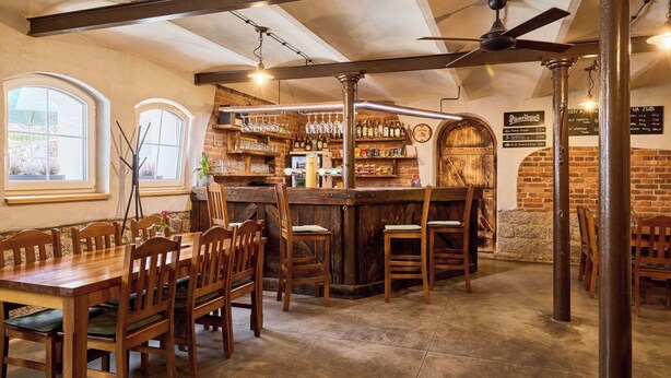 Eine Bar mit Holzbemöbelung, einer Ziegelwand und einer Speisekarte.