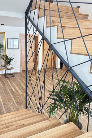 Eine Wendeltreppe mit Holzbodenstufen und einem Metallgeländer, die zu einer oberen Etage führt.