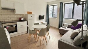 A compact living space with a kitchenette, dining area, and seating area with a view. - Shoreditch Apartments by PrimeCityHosts F6 (Greater London)