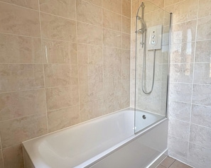 A modern bathroom with a glass-enclosed shower, a white bathtub, and beige tiled walls. - Shoreditch Apartments by PrimeCityHosts F6 (Greater London)