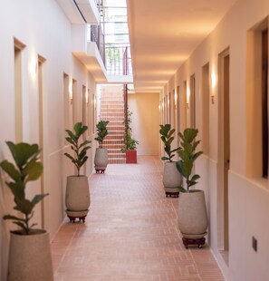A corridor with potted plants, a staircase, and a balcony with railings. - Casa del Huesped by 3Villas (Santa Marta)