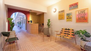 A hallway with a reception desk, chairs, and potted plants. - Casa del Huesped by 3Villas (Santa Marta)
