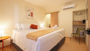 A hotel room with a large bed, a small table, a chair, and an air conditioning unit on the wall. - Casa del Huesped by 3Villas (Santa Marta)