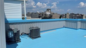 A rooftop with a blue surface, a white garage door, and two air conditioning units. - P3E. Near MET Peaceful 2-bedrooms 2 bathrooms entire apartment. (Philadelphia)