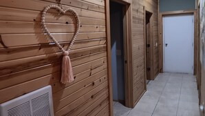 A hallway with wooden paneling, a heart-shaped decoration, and a door at the end. - Pleasant 3-bedroom bungalow with AC in charming Clearfield (Clearfield)