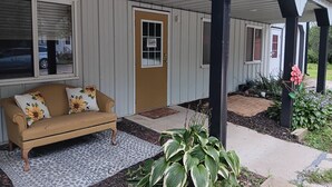 A covered porch with a sofa and potted plants. - Pleasant 3-bedroom bungalow with AC in charming Clearfield (Clearfield)
