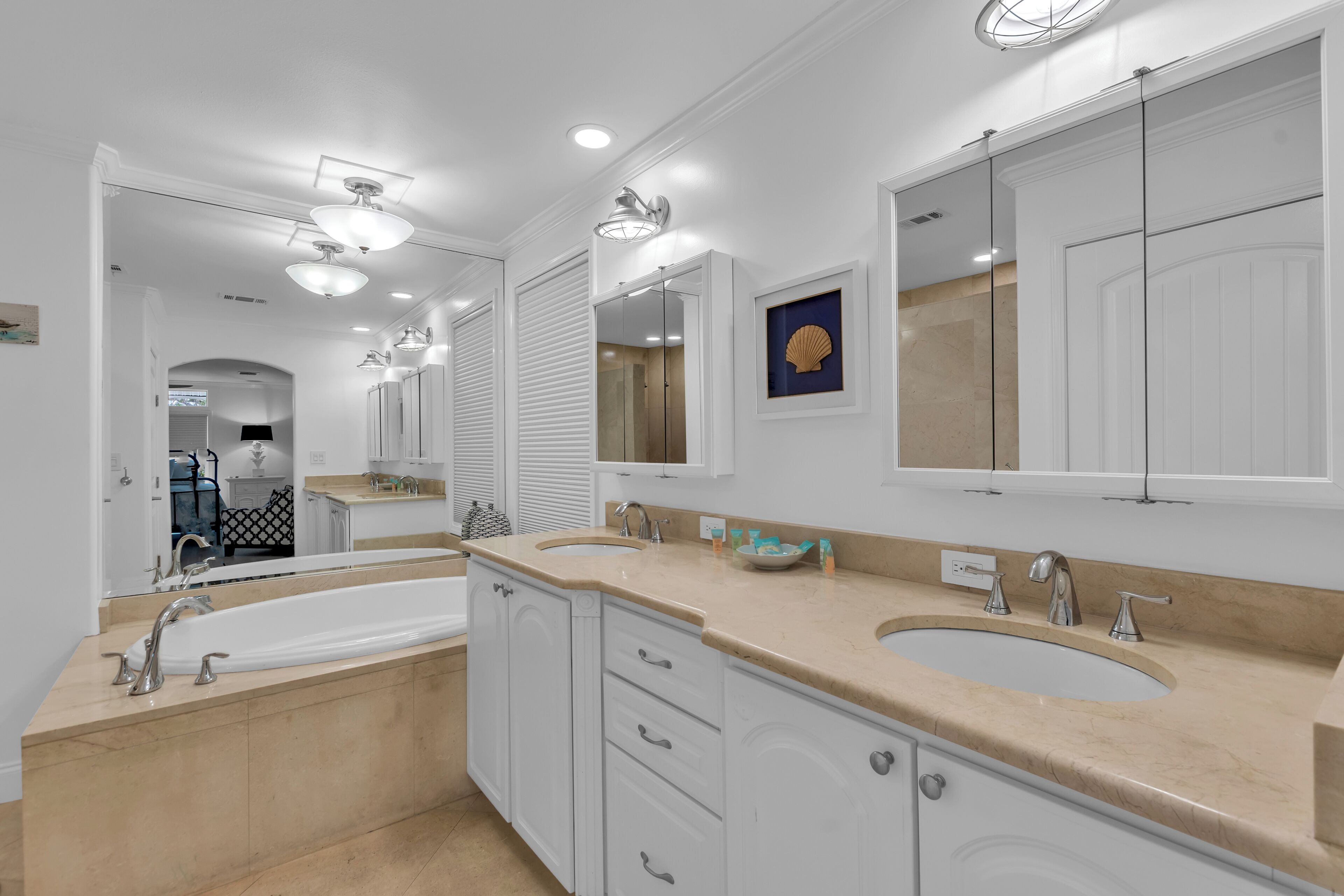 A bathroom with two sinks, a bathtub, and a large mirror.