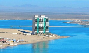 Un hotel moderno de gran altura con varios pisos, ubicado cerca de una masa de agua.