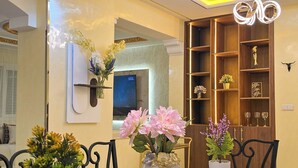 Een eetruimte met een houten tafel, stoelen en decoratieve vazen met bloemen.