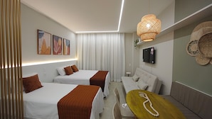 A modern hotel room with two beds, a sofa, a TV, and a small table. - Premium Flat Golden Beach Beachfront Piedade (Jaboatão dos Guararapes)