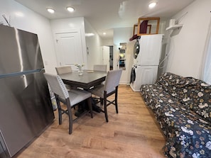 A compact living space with a dining table, chairs, a sofa, a washing machine, and a refrigerator. - S1E. Queen Villege, 2 bedrooms 1 bathroom entire apartment. (Philadelphia)