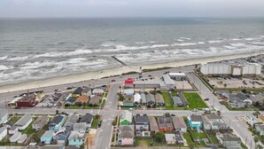 A coastal residential area with houses, a beach, and a road leading to the beach. - Tide of Your Life | Walk to Beach | Seawall (Galveston)